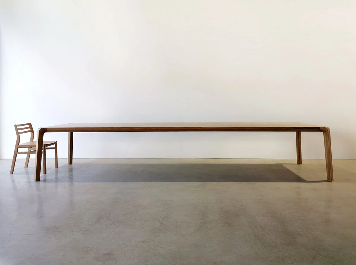 Full side view of the Araluen Table's 4 metre span in Walnut, minimalist studio setting - Nathan Day Design