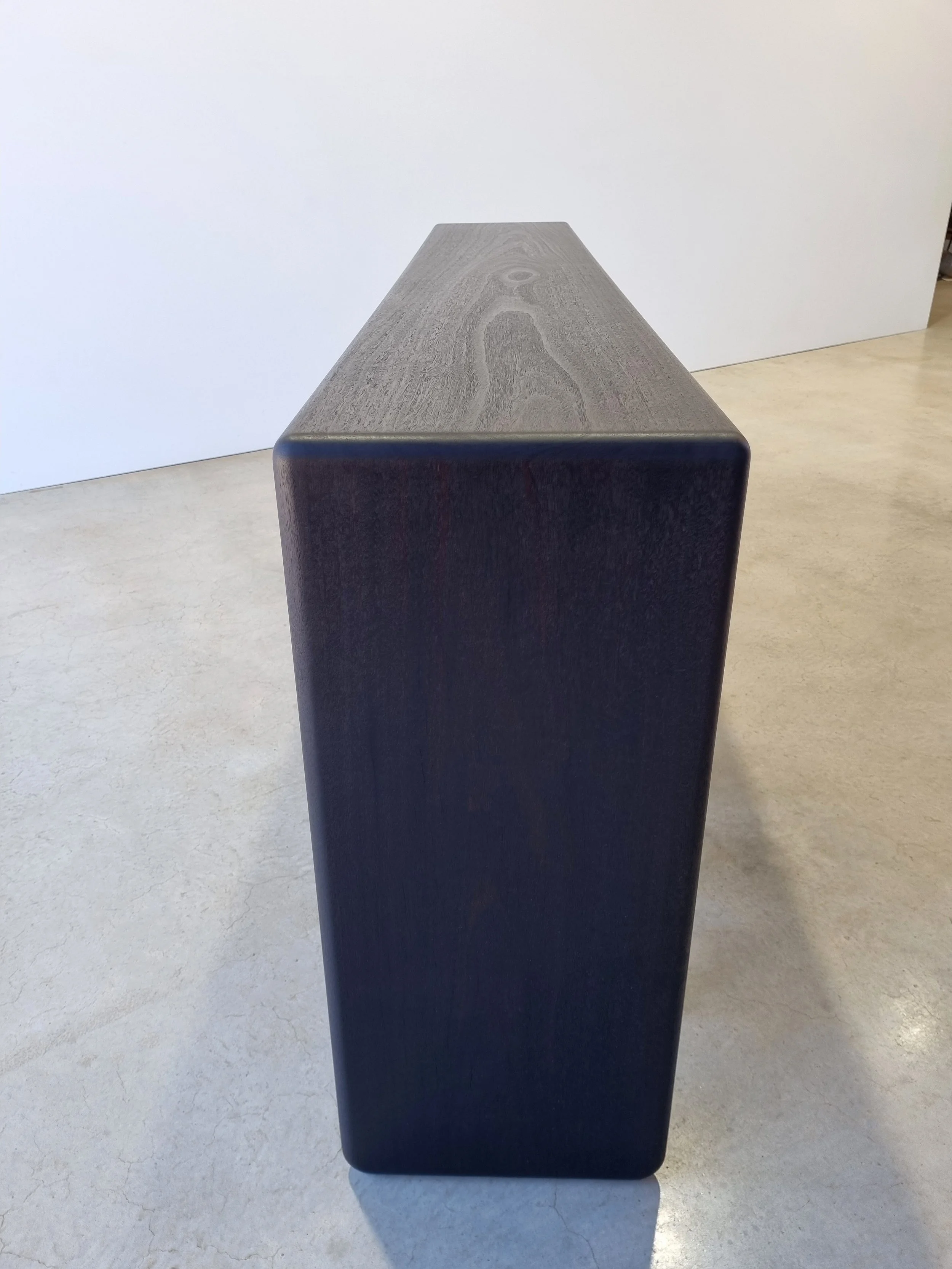 Millipede Console in ebonised Jarrah, end-on view showing tapered fin profile - Nathan Day Design