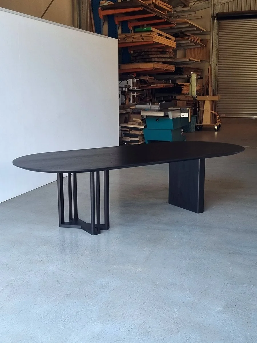 Oval-top Giacci Table in ebonised Walnut in the Nathan Day Design workshop, asymmetrical leg design