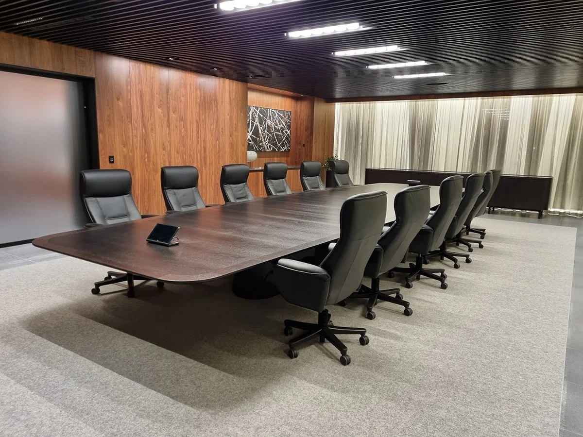 Walters Drive Boardroom Table in ebonised Walnut - Nathan Day Design, angled side view against timber-panelled wall with artwork