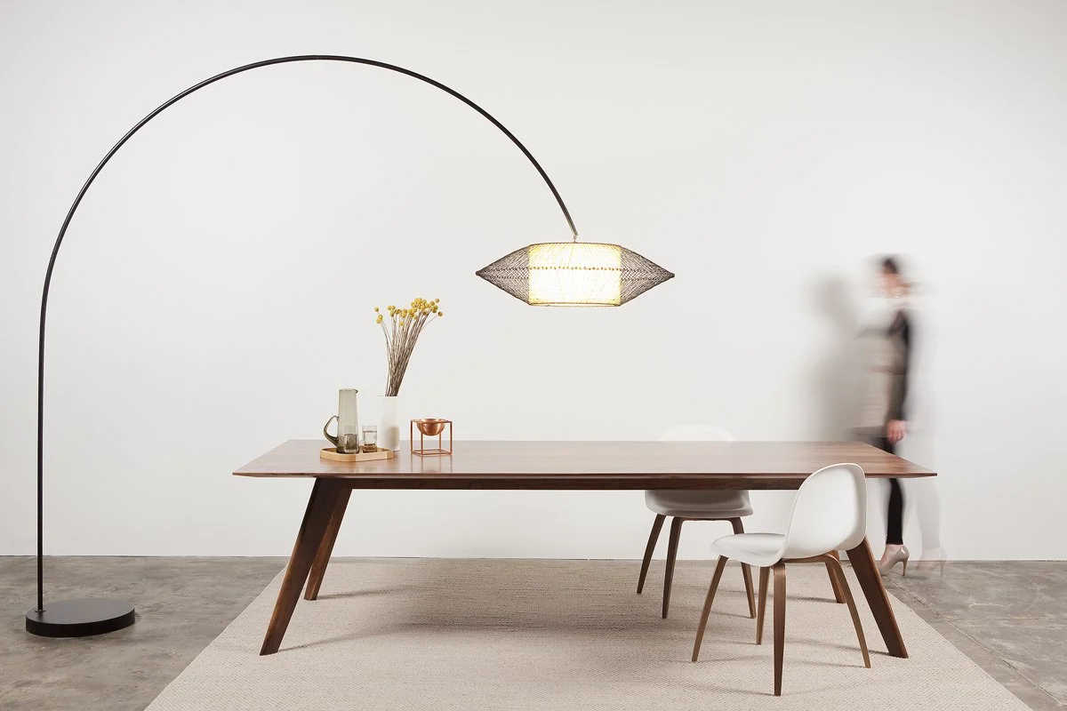 Vista St Table in Walnut styled in a living space with white dining chairs, arc floor lamp and rug - bespoke furniture by Nathan Day Design