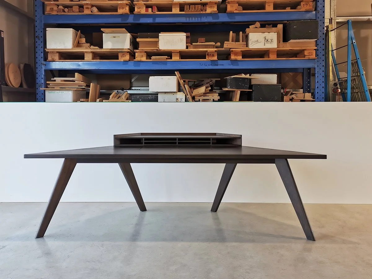 Vista St Desk in ebonised Tasmanian Blackwood, splayed leg design with raised cable organiser, workshop setting - Nathan Day Design
