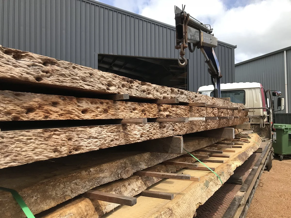 DWER custom furniture in WA Blackbutt - Nathan Day Design, raw Blackbutt timber slabs on delivery truck with crane