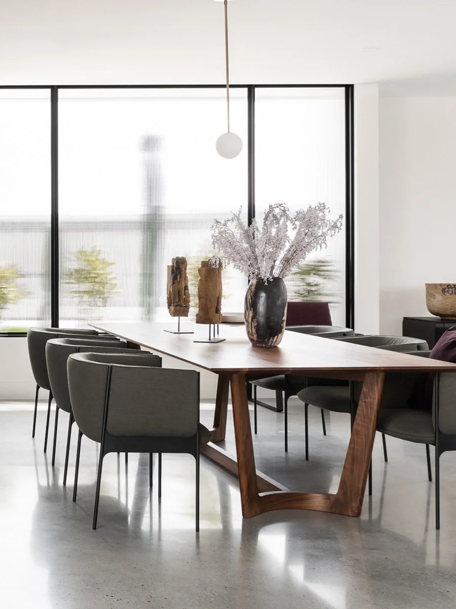 Froxfield Table in Walnut styled in a light-filled dining room with upholstered chairs - Nathan Day Design