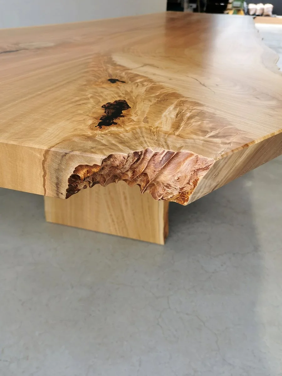 Close-up detail of natural burl void and bark inclusion along the live edge of a Marri slab tabletop - bespoke furniture by Nathan Day Design