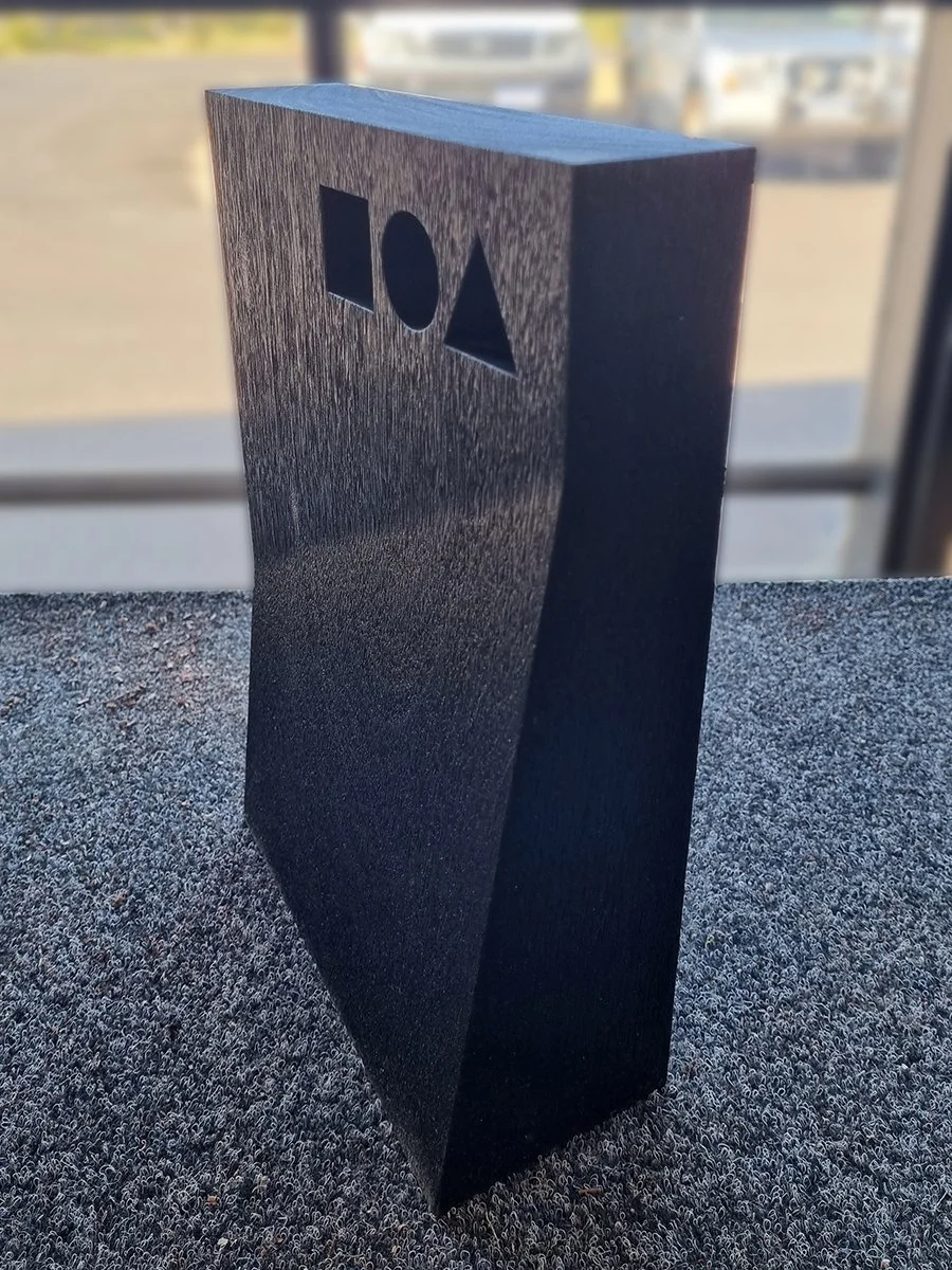 DIA Awards Trophies in scorched Jarrah - Nathan Day Design, single trophy block outdoors showing cut-out silhouettes