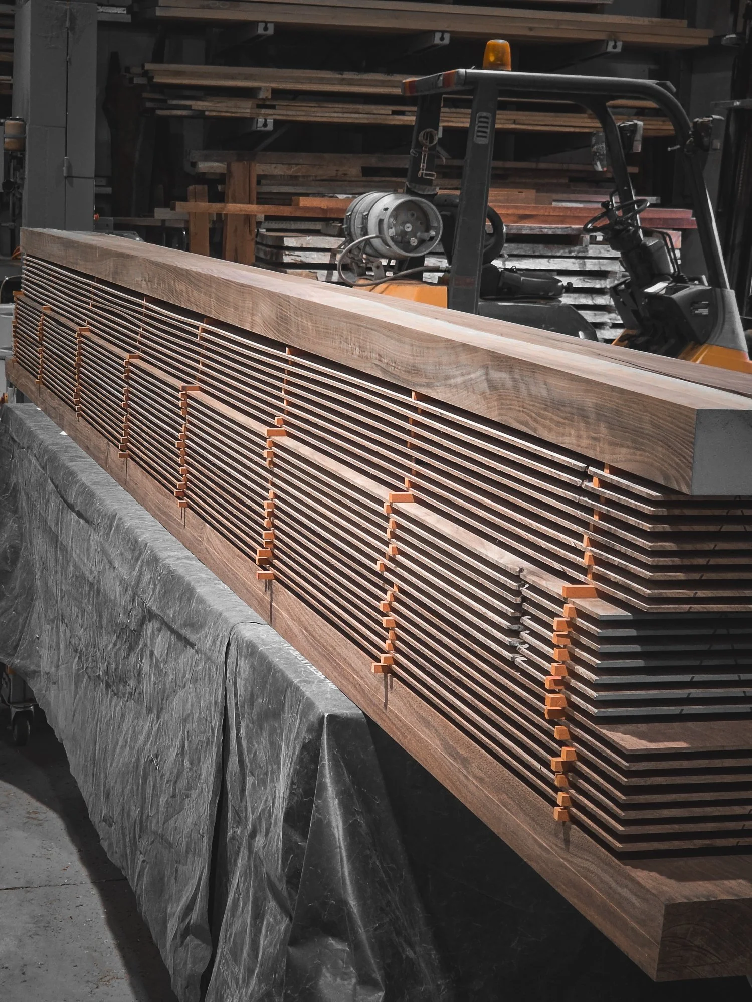 Timber veneer strips being clamped and laminated to form a fluted panel in the Nathan Day Design workshop
