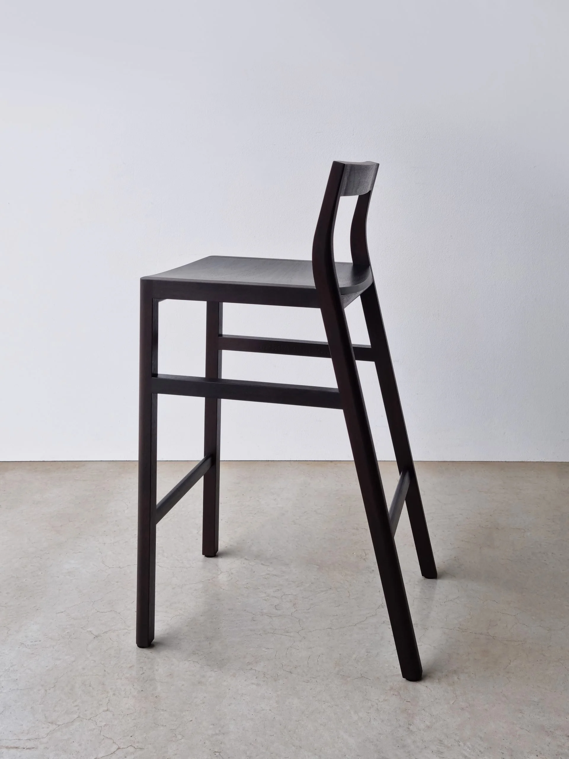 Low-back Bar Stool in ebonised Jarrah, Nathan Day Design bespoke furniture - full side view in plain studio setting