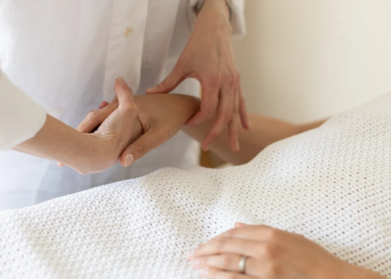 Acupuncturist taking a lady's pulse