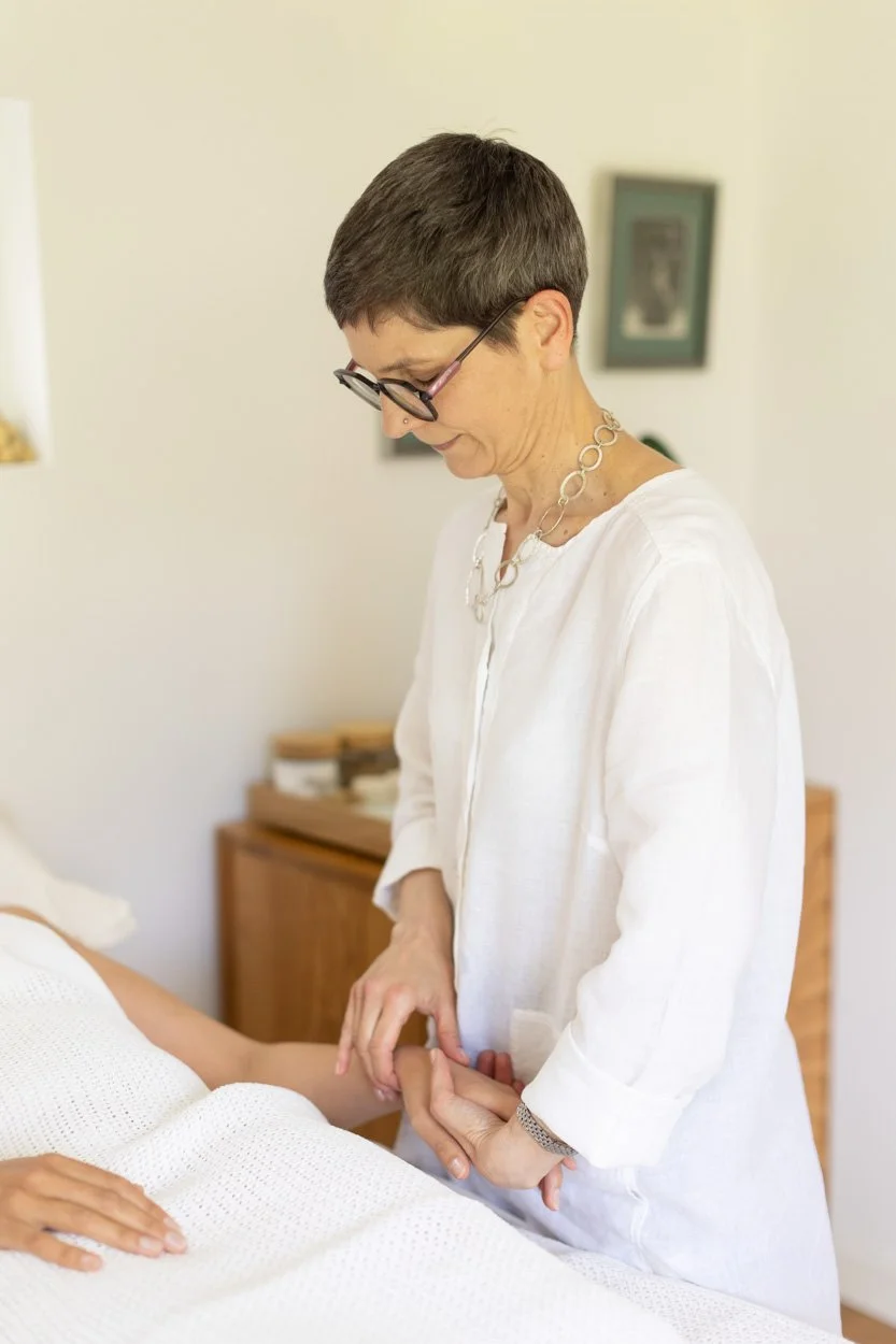 acupuncturist delivering a treatment in a treatment room