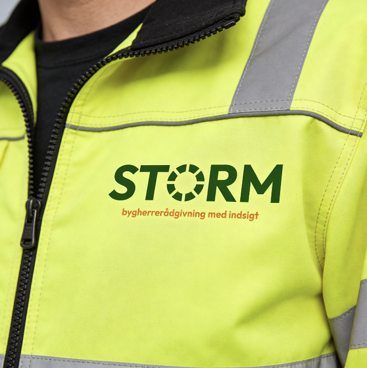 Nærbillede af en persons overkrop iført en høj synlighedsvest med logoet 'STORM' og teksten 'byghereraadgivning med indsigt' på brystet.