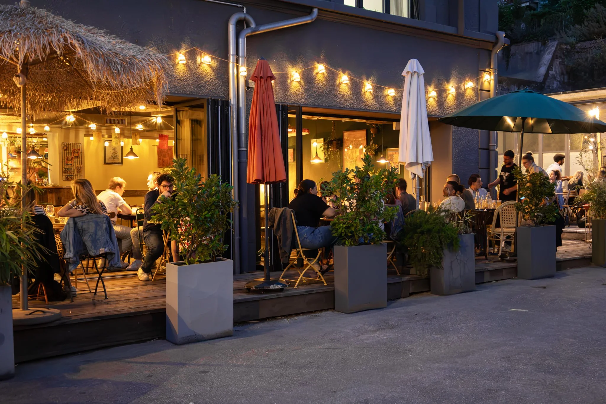 Terrasse du restaurant Yada en soirée, guirlandes lumineuses et clients attablés