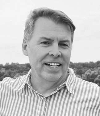 Author Philip D. Adams smiling outdoors in a nature background.