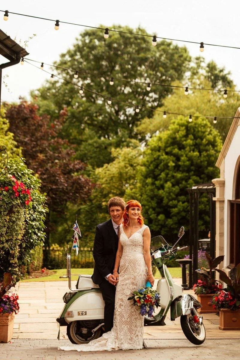 Mod indie style wedding photography at the King Arthur, just married couple leaning against a vintage Vespa outside the Gower wedding venue in South Wales. 