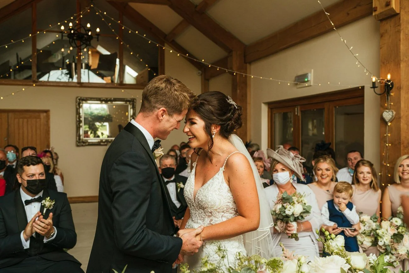 Oldwalls wedding ceremony photography,  in action, candid laughing bride and groom during their wedding ceremony in the luxury Swansea venue. A natural happy moment as they become husband and wife newlyweds. 