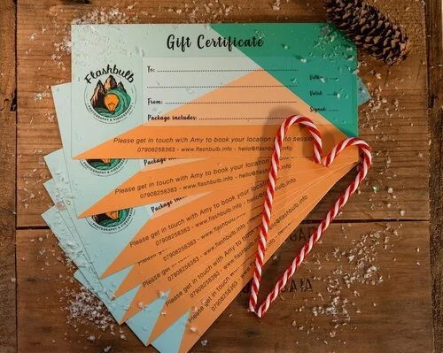 Flashbulb branded fan shape of gift vouchers for photoshoots, blank lines ready to be filled in. There is two candy canes on top.