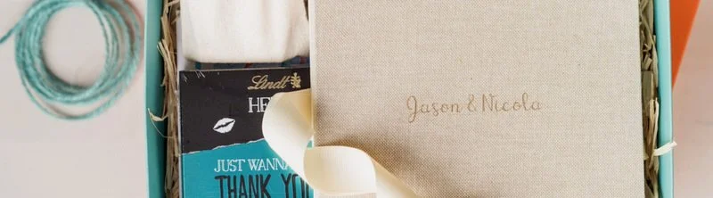 Display of a luxury linen wedding album in a box with Lindt chocolates and Flashbulb branding.