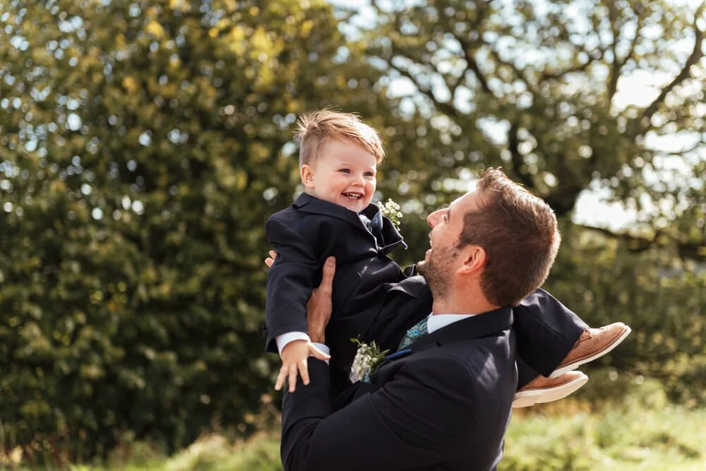 Dad and son playing aeroplanes.