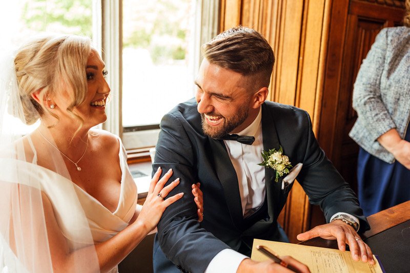 Natural laughing bride and groom during signing