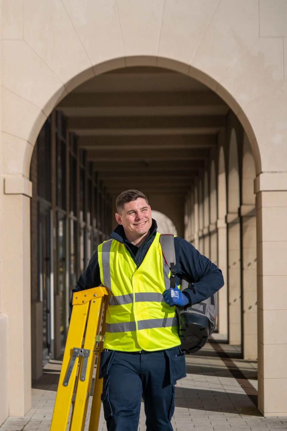 Record employee walking carrying a ladder for a corporate photo session in swansea-university.
