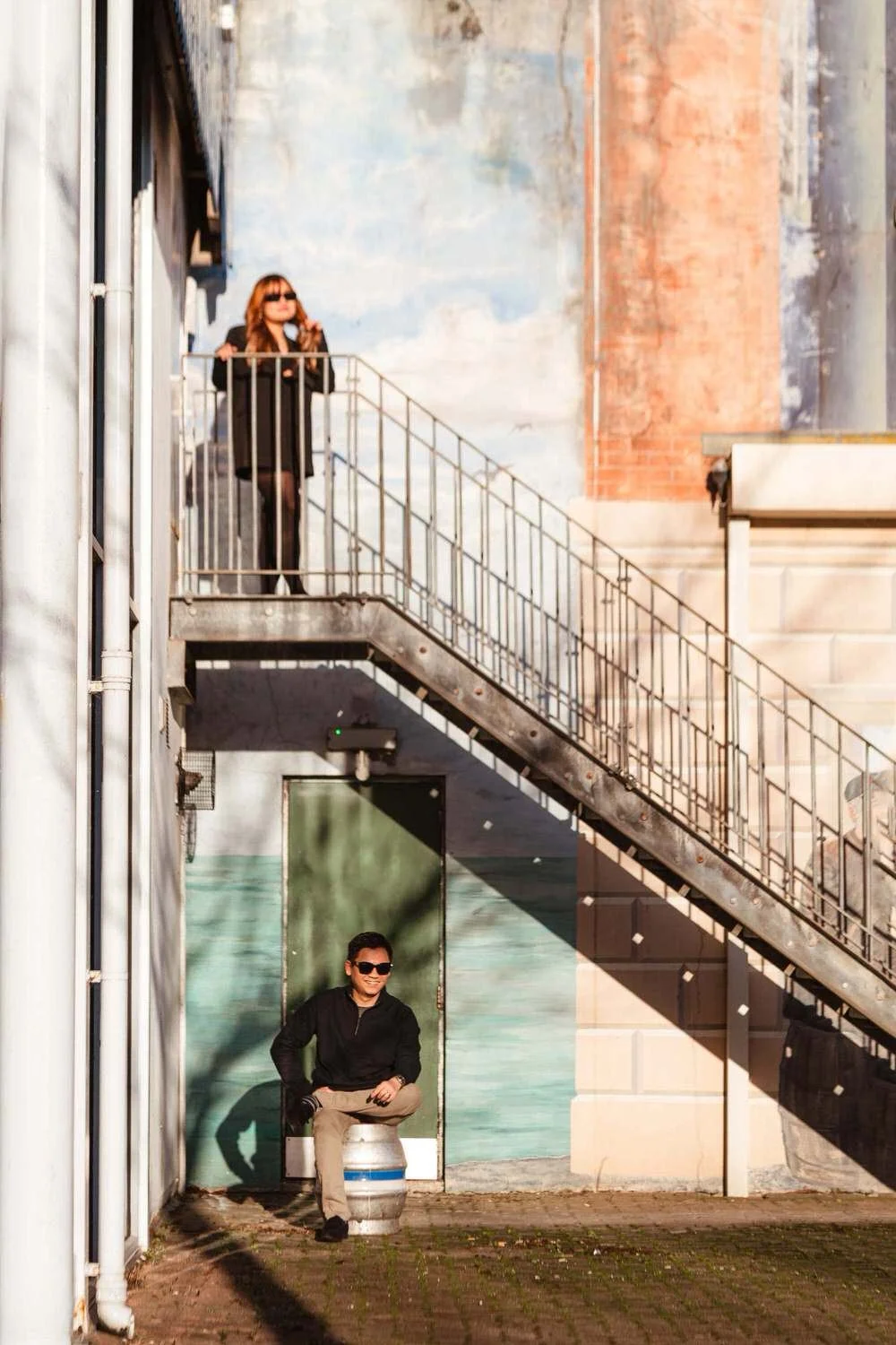Cool asian couple having fun on a staircase in Swansea Marina for their engagement photo-shoot.