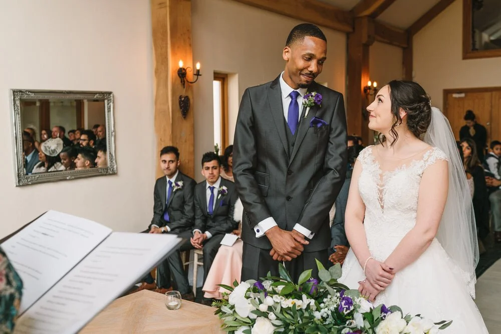 Romantic moment during a wedding ceremony at Oldwalls in Swansea, as the couple look lovingly at each other.