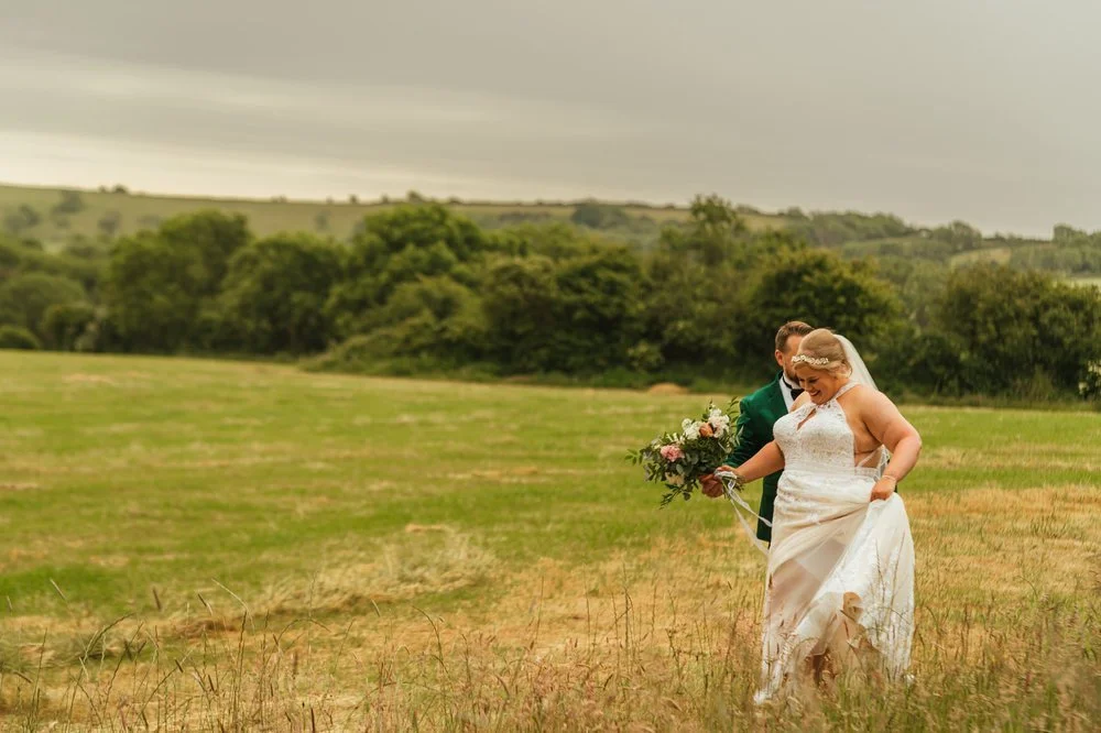 Wedding couple walking through field