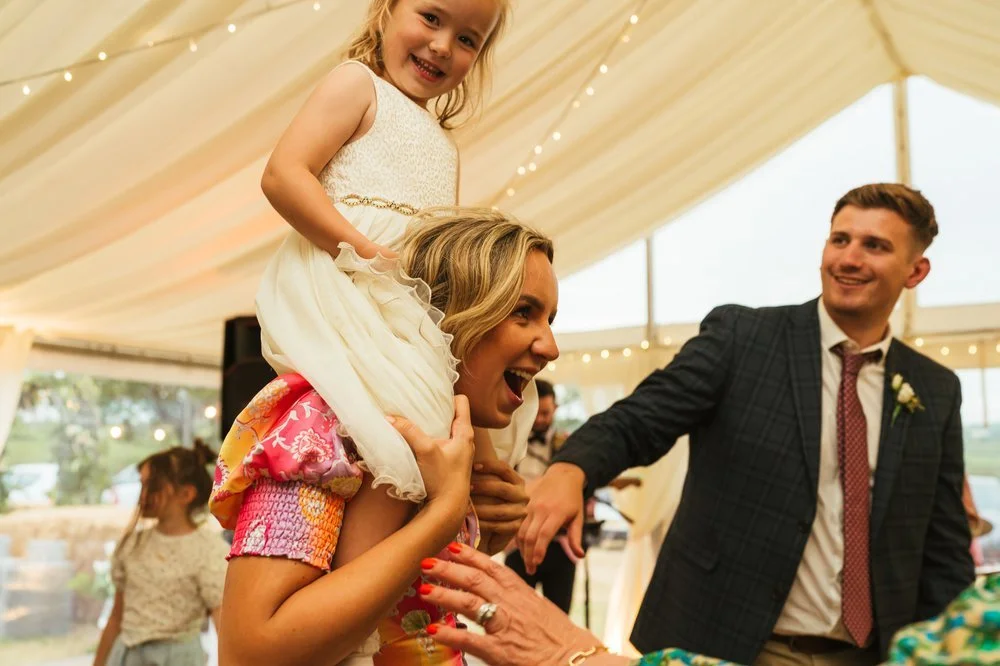 Flowergirl on shoulders dancing.