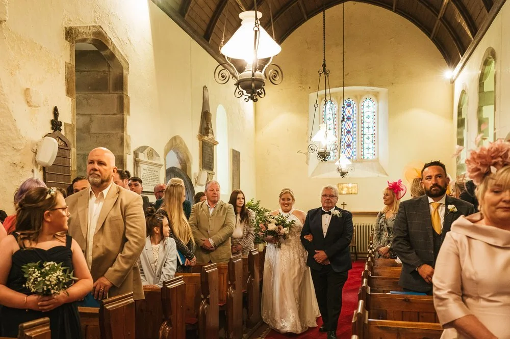 Bride walking down church aisle 