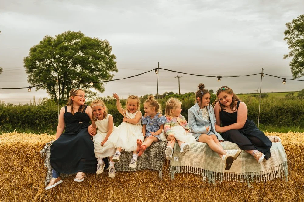 Bridesmaids giggling on hay bales