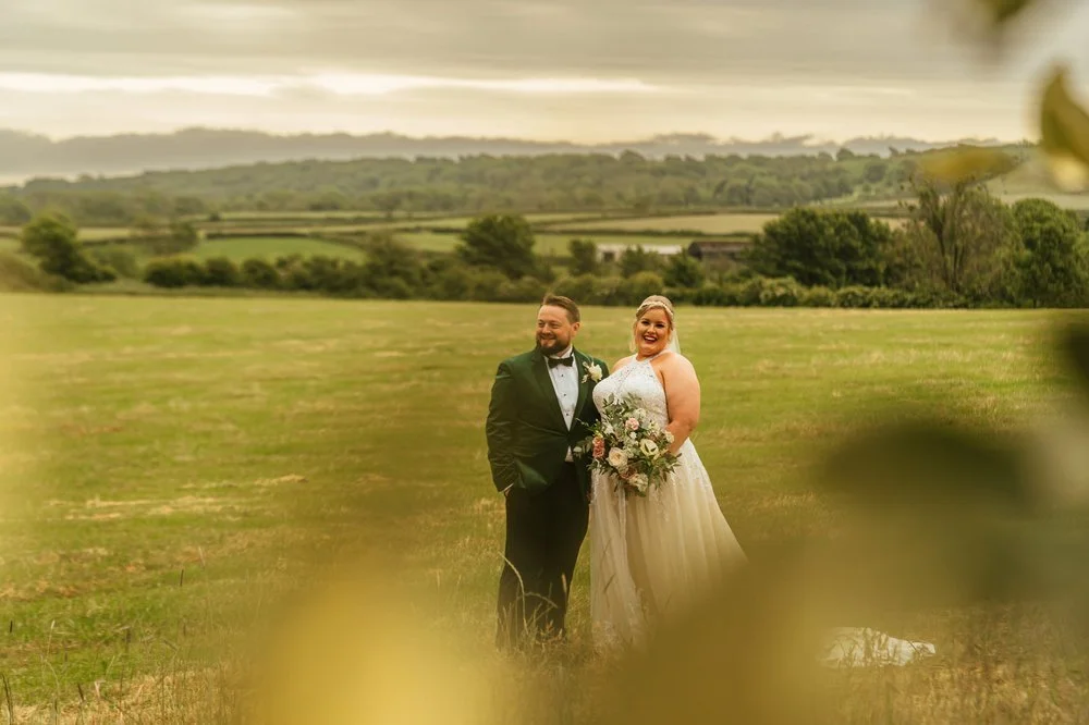 Bride and groom in long grass field