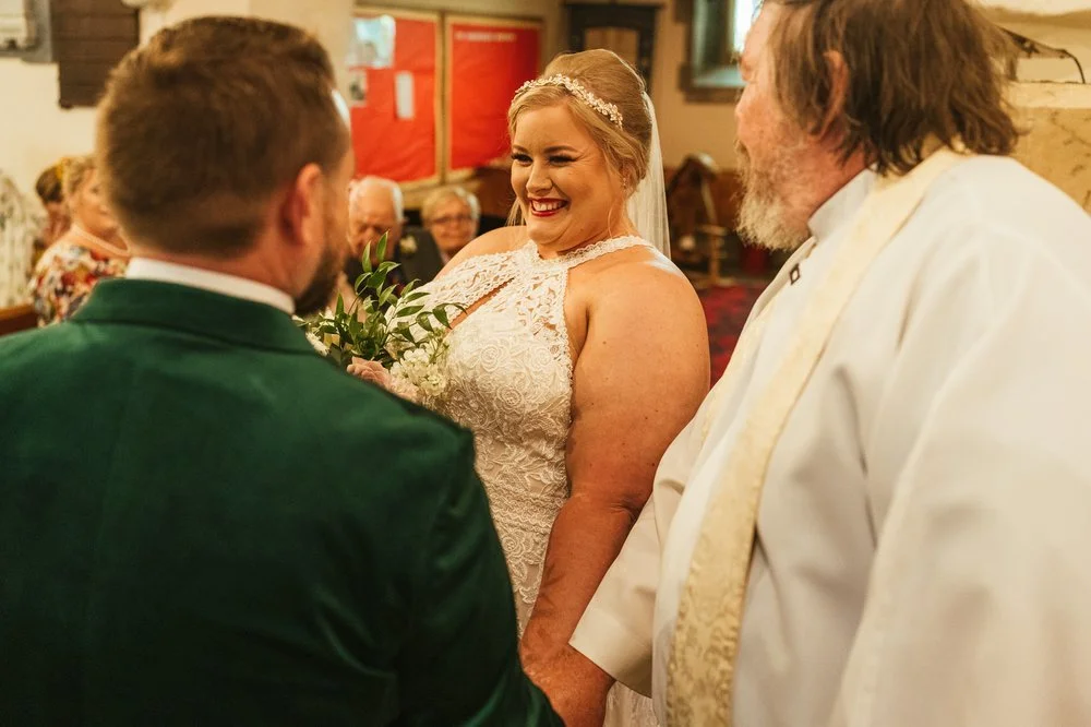 Bride laughing with priest