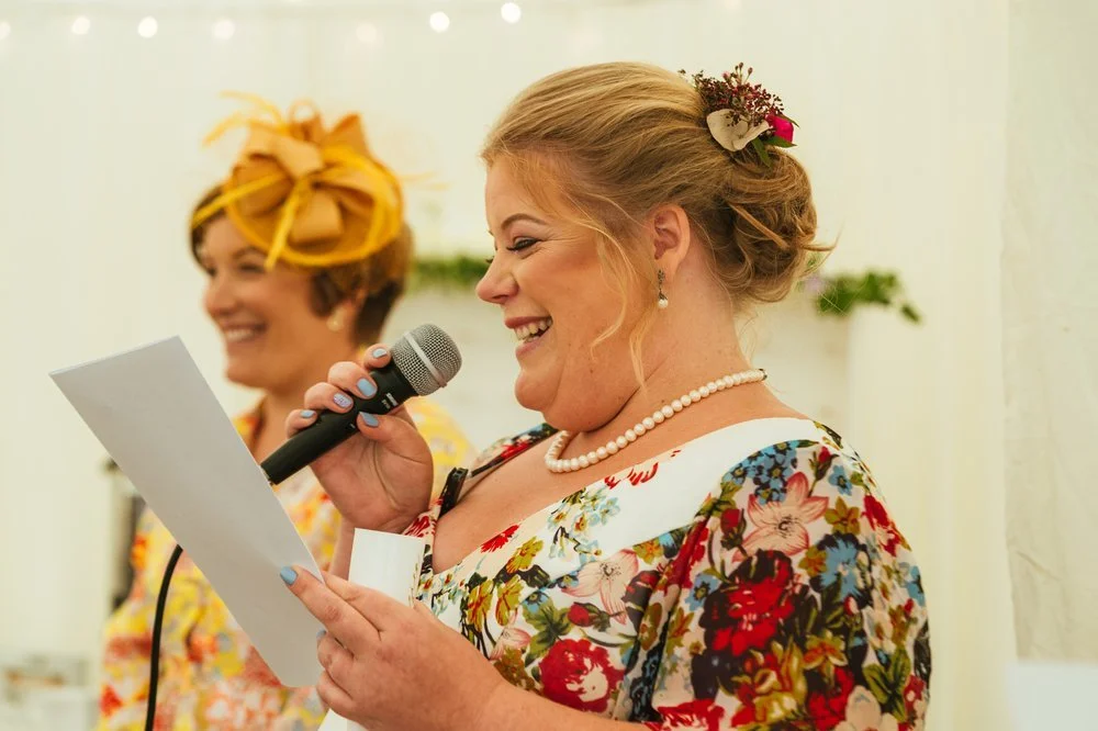 Bridesmaid laughing during speech 