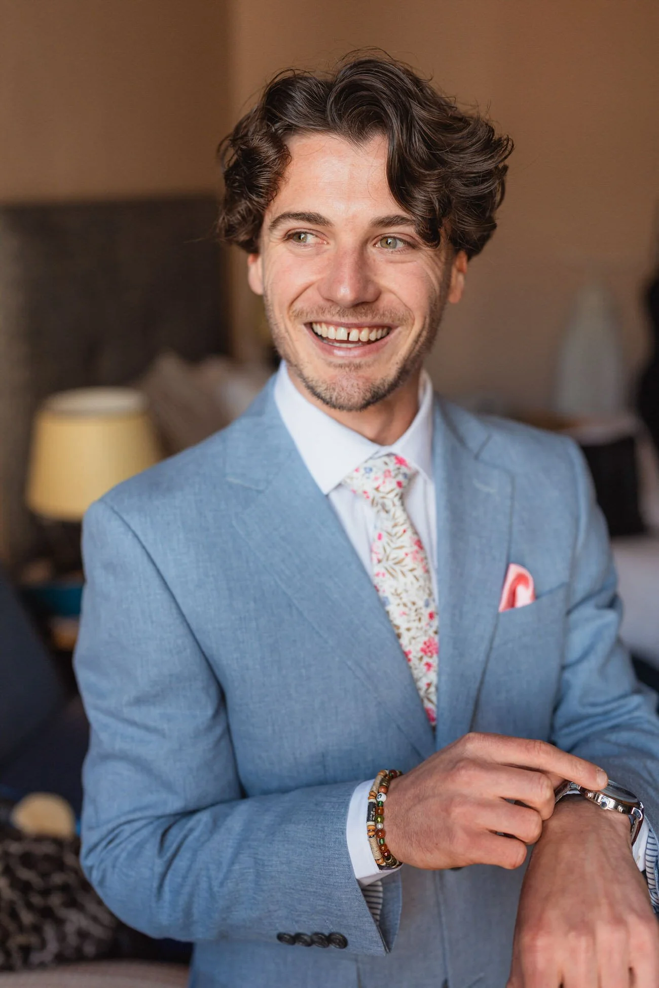 Happy man in a light blue suit and flower tie, getting ready for his wedding at the Green Dragon hotel in Hereford.