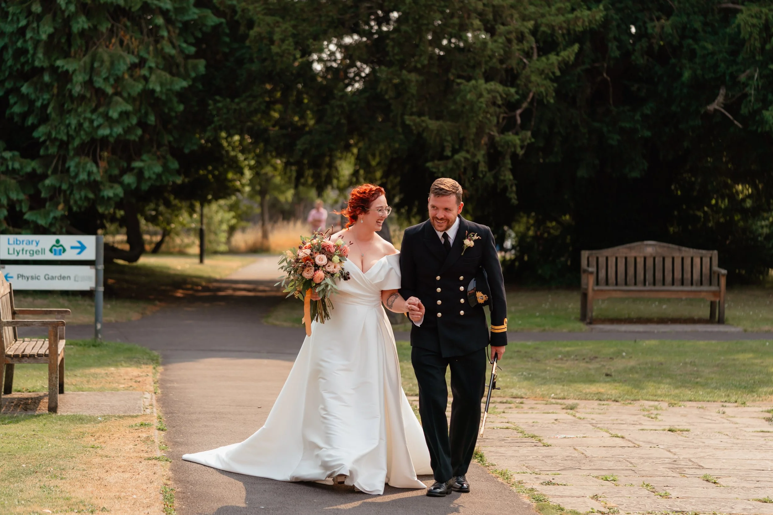 Happy wedding couple walking through the Physic garden in Cowbridge