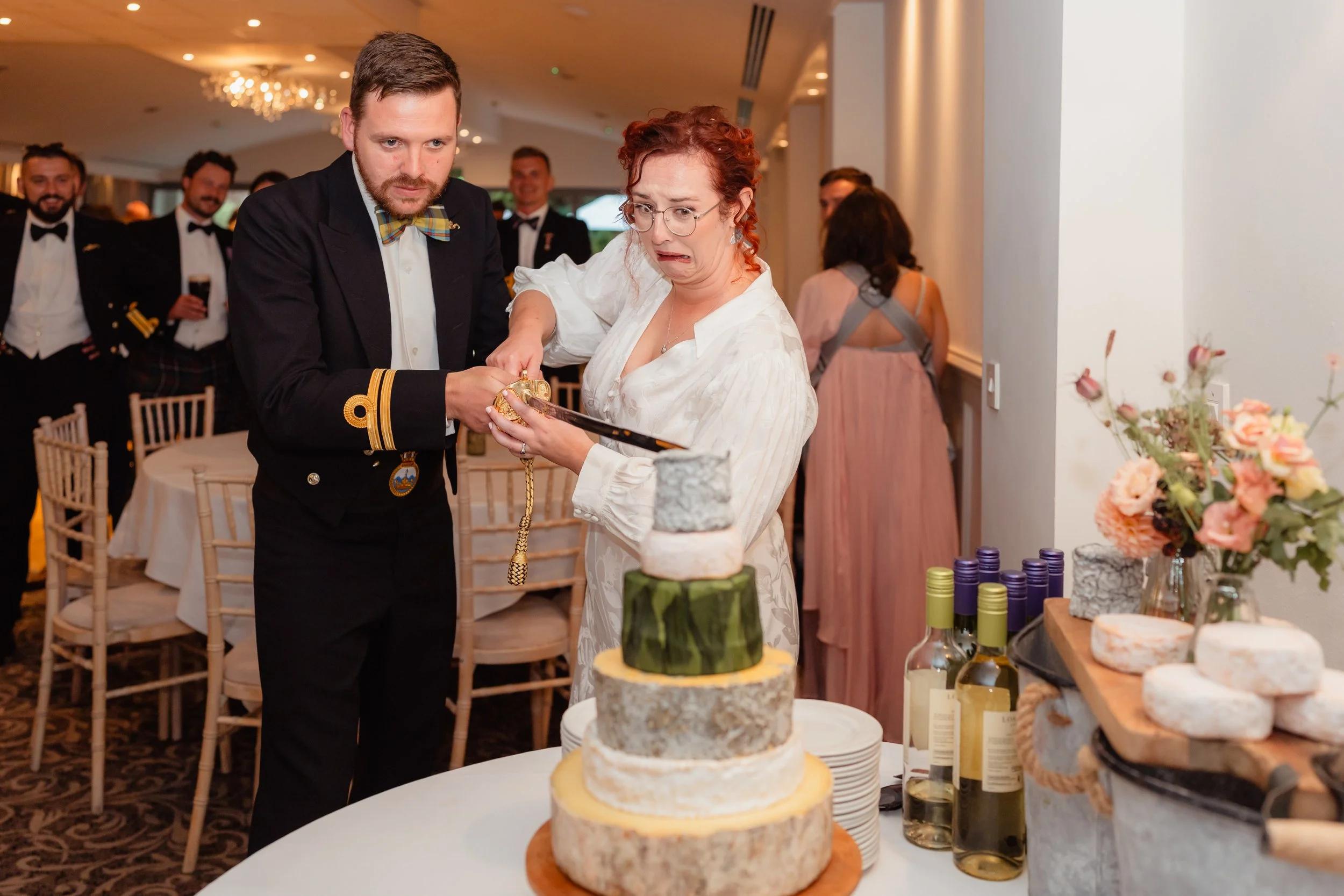 Wedding couple cutting their tiered wedding cheese cake at the Bear hotel in Cowbridge, South Wales