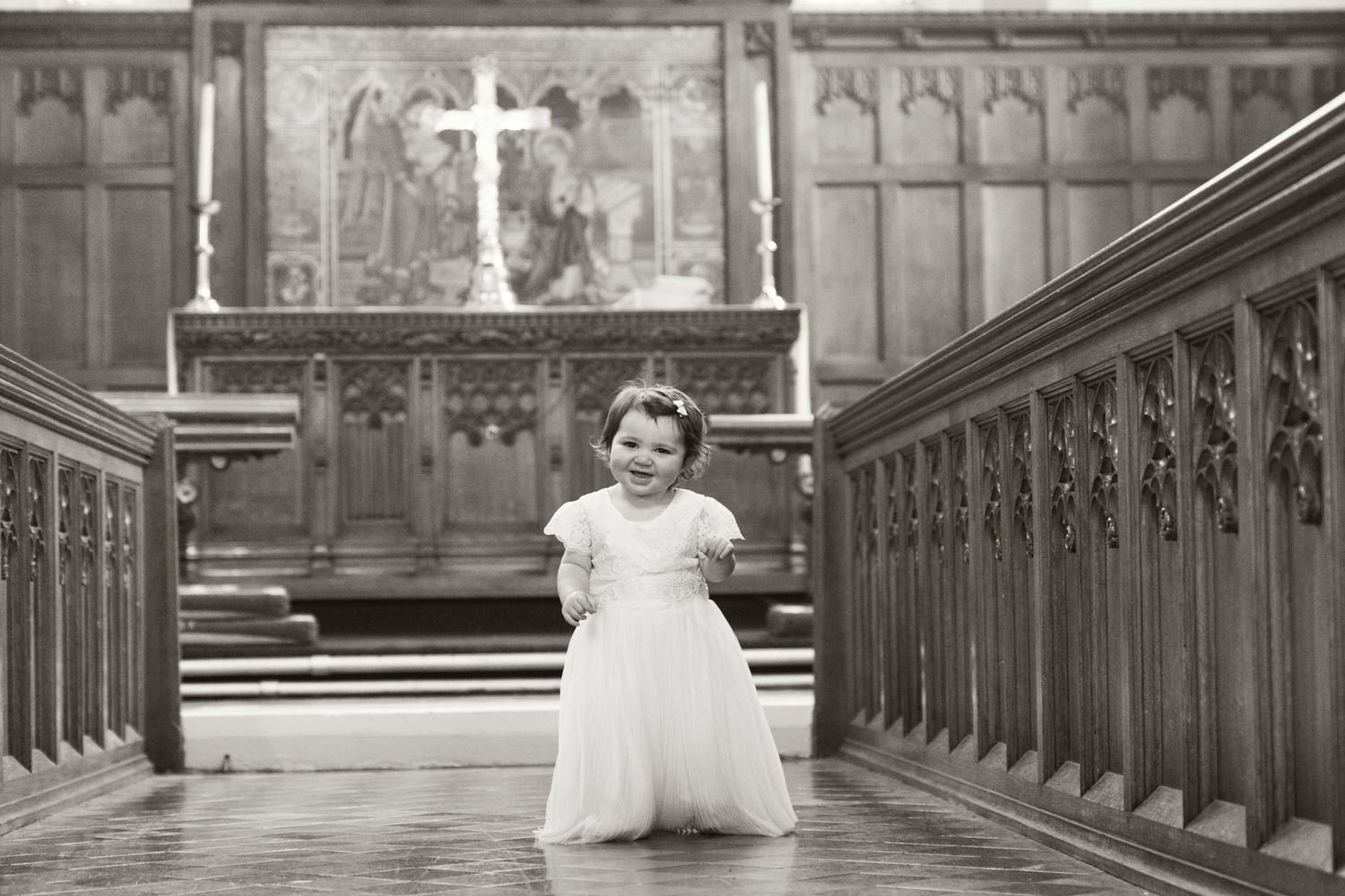 Candid photograph of a young child being christened at Samlet church in Swansea.