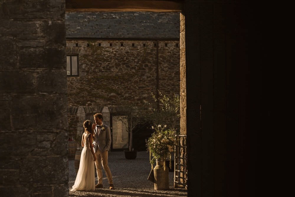 Documentary style imagine of a bride and groom waiting to be called through to their wedding breakfast at the Anrán farm in Devon.
