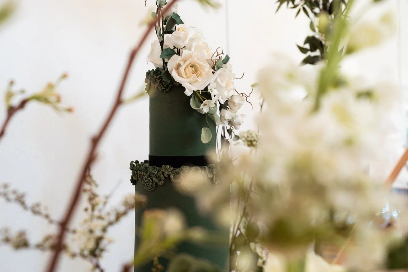 Green Flora  Soft green and white floral wedding cake styled with vintage cart and floral urns in cream tones