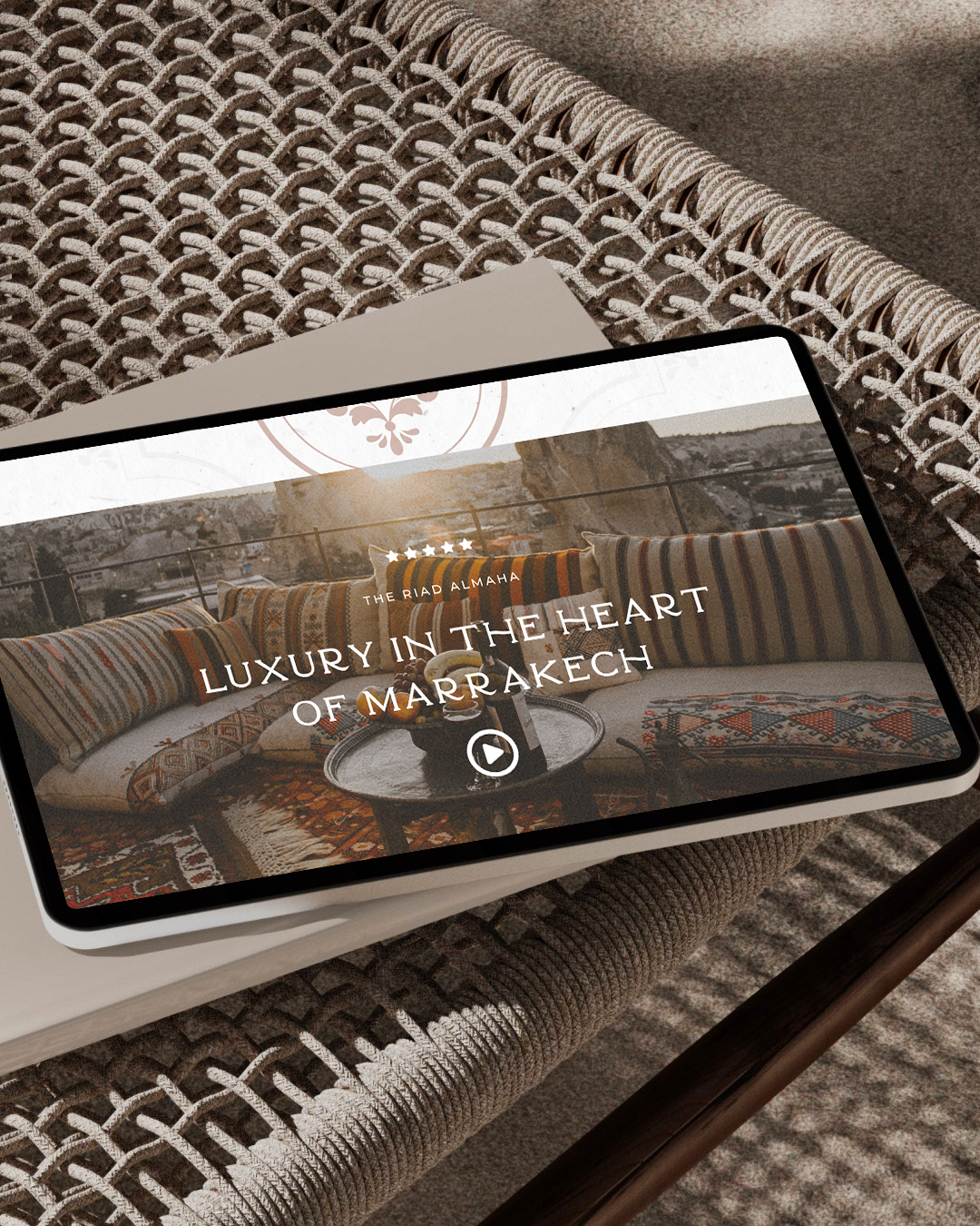 Igni Made | Copywriting, Branding & Websites for Wellness, Hospitality and Creative Businesses | Northern California | Tablet displaying a tourism video titled 'Luxury in the Heart of Marrakech' on a woven rattan table