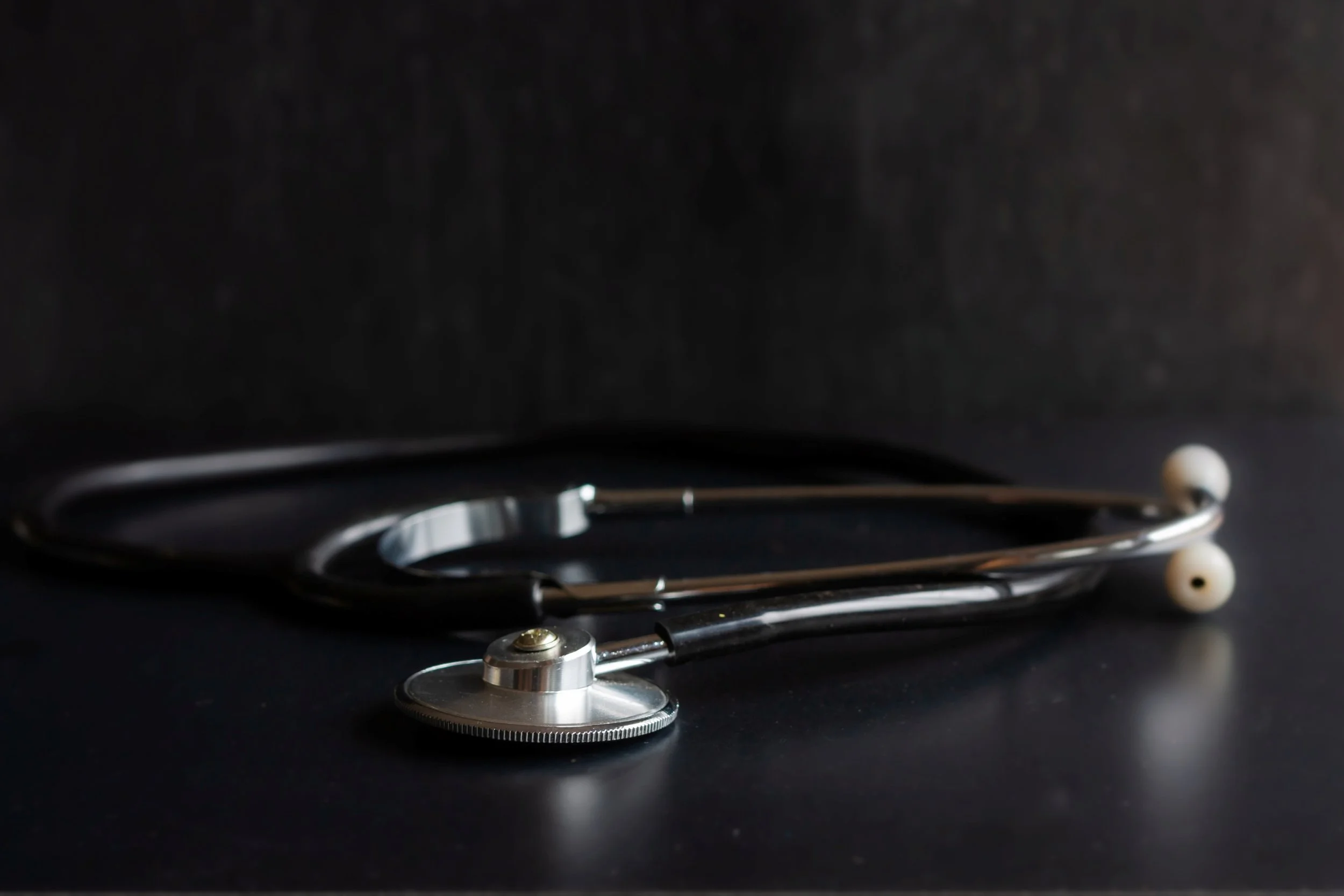 Stethoscope on a dark wooden table representing specialist cardiology and heart rhythm care with Dr. William Eysenck, London