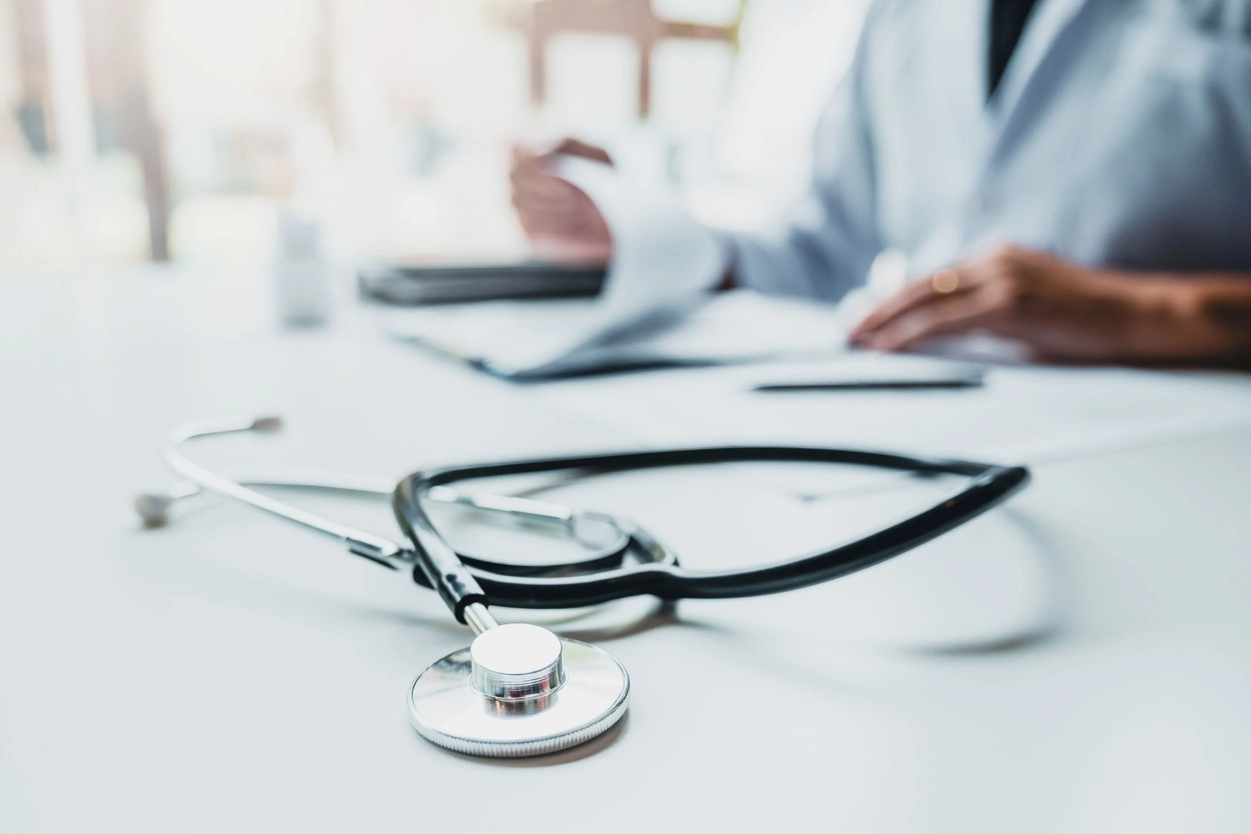 Doctor at a desk with a stethoscope on the table during a private cardiology consultation