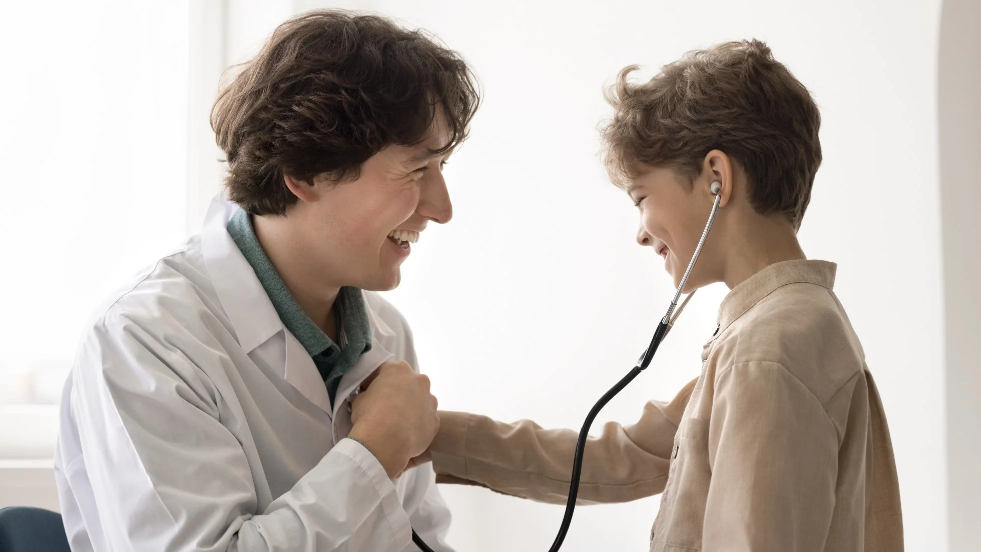 Child listening to doctor's heartbeat with a stethoscope during a friendly cardiology consultation, WE Cardiology, London