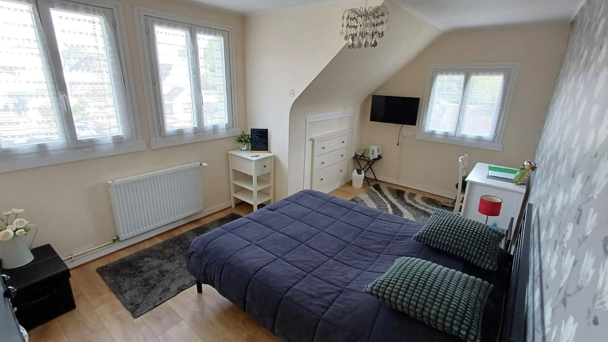 Main bedroom in the two-bedroom guest suite at Numéro 1 B&B in Châteaulin, Brittany, showing a cozy bed and bright interior.