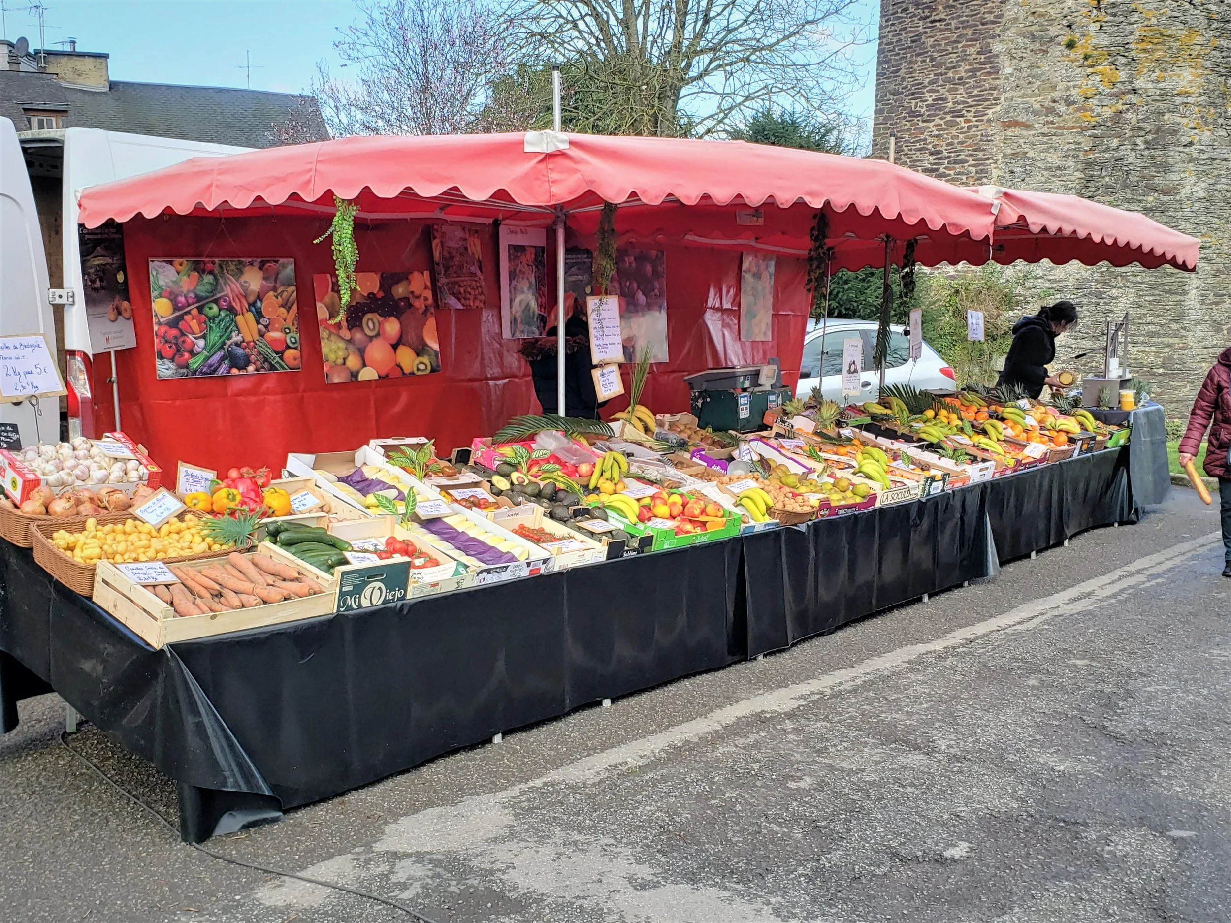 A colourful fruit and vegetable stand at the weekly Friday farmers market in Ploërmel, France, one of the best and most well-stocked outdoor markets in central Brittany, and the featured photo on the Google Maps page for the Marché de Ploërmel.
