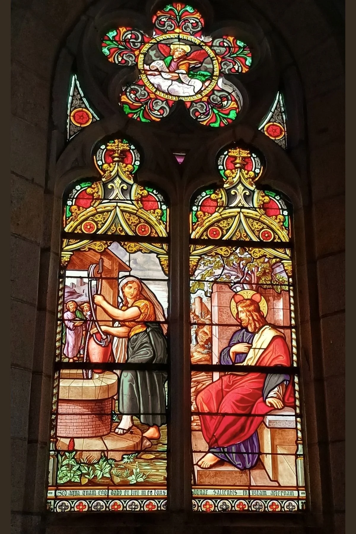 Stained glass window inside Église Saint-Idunet in Châteaulin depicting Jesus seated at Jacob's well conversing with the Samaritan woman.