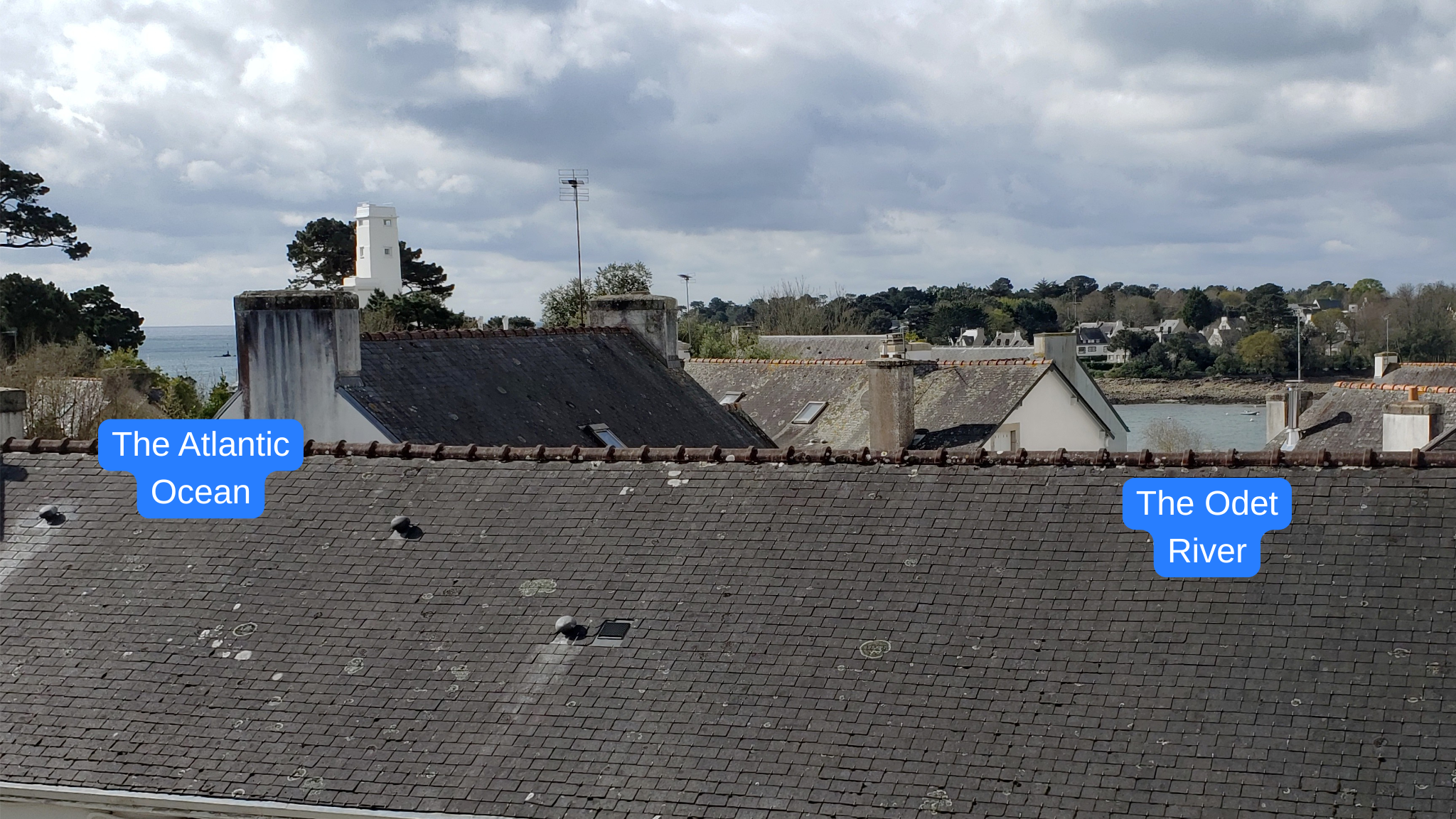 Peek views of the Bay of Biscay and the Odet River between rooftops in Bénodet, France