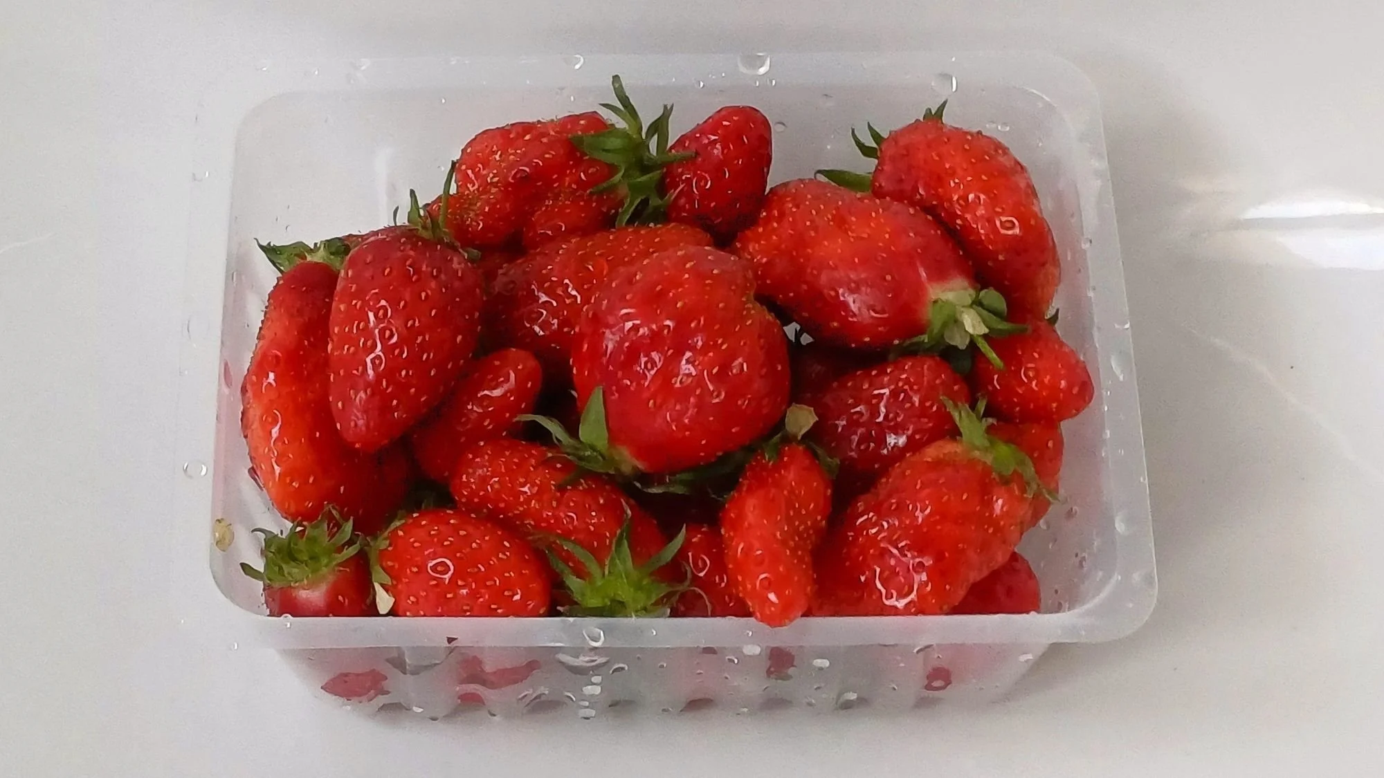 A basket of fresh, bright red Plougastel strawberries from the weekly market in Châteaulin, France.