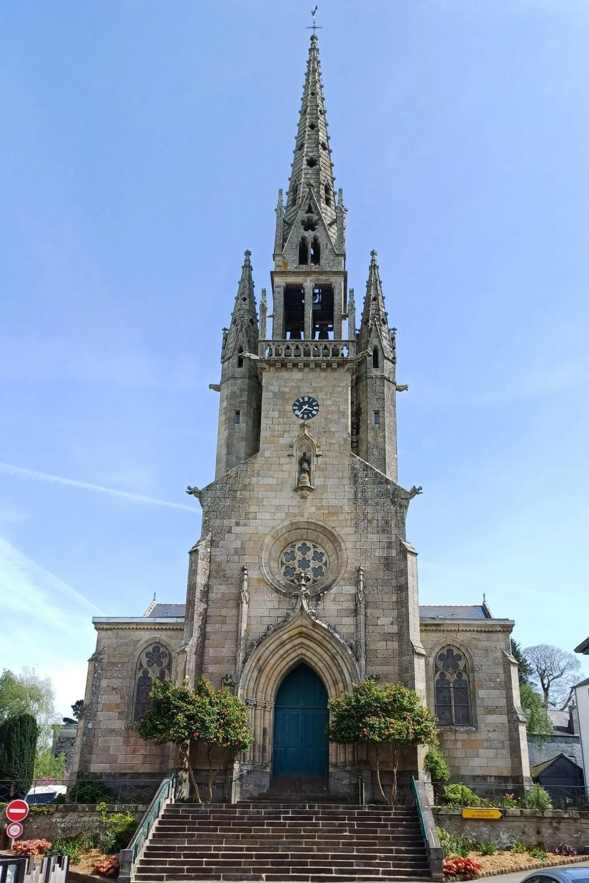 Front exterior view of Église Saint-Idunet in Châteaulin, featuring its stone bell tower and entrance along the Aulne River in Brittany, France.