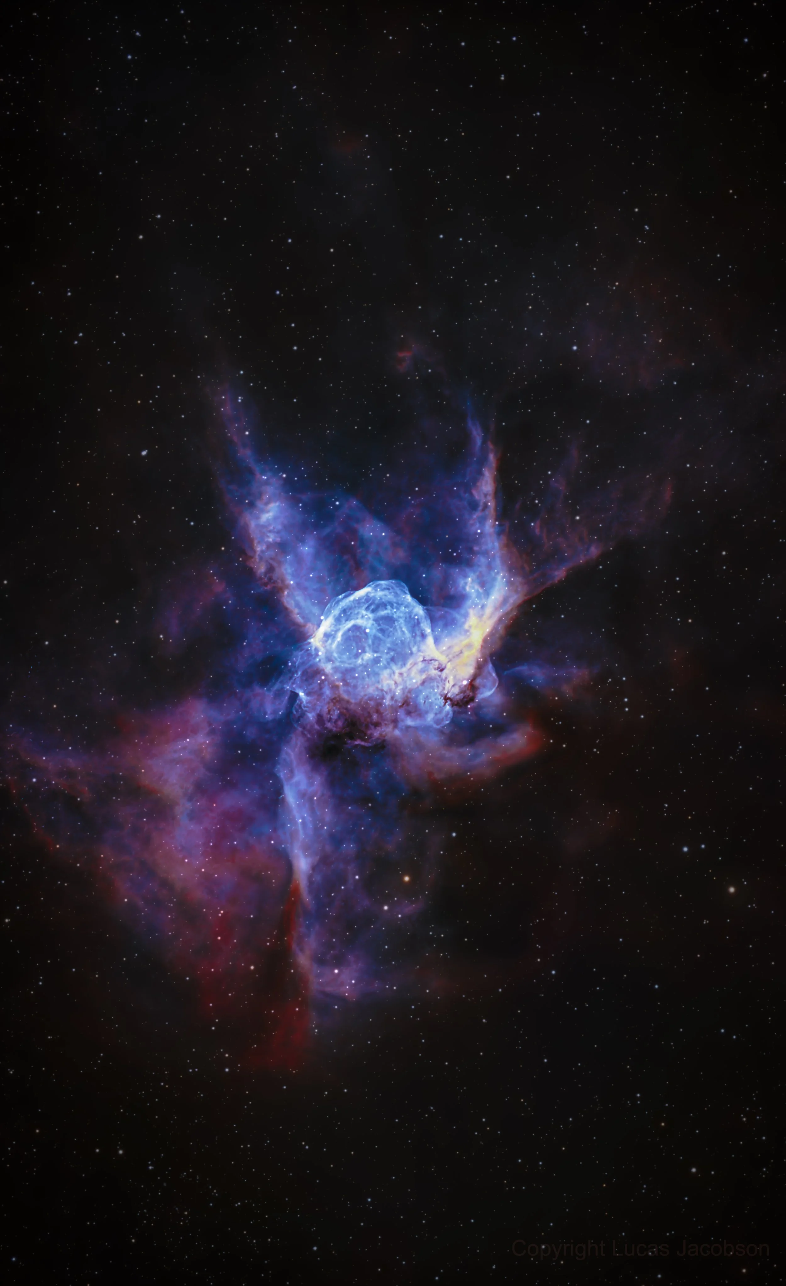 Colorful image of a deep space nebula with bright blue and purple gases and stars scattered across the background.